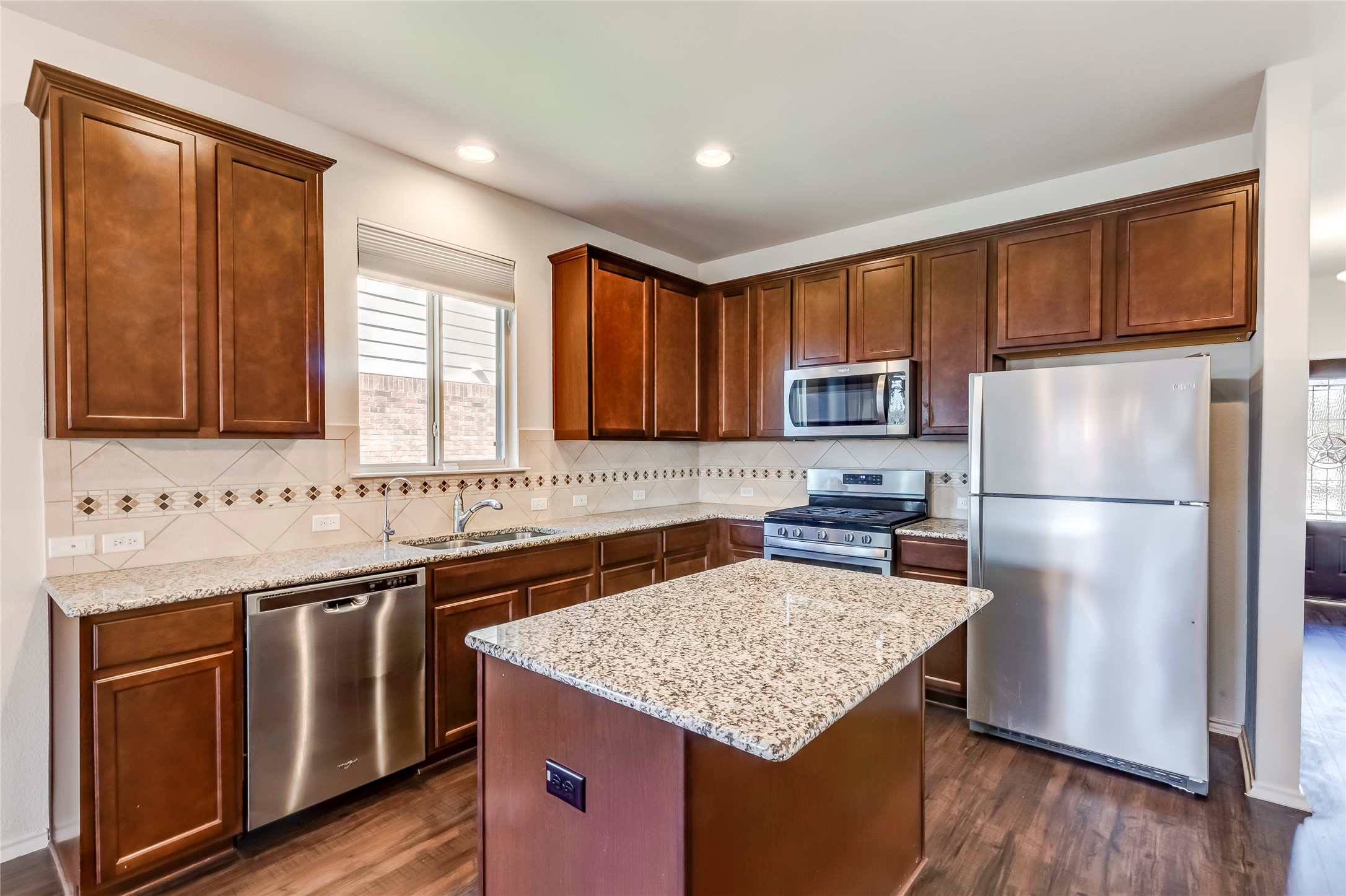 11617 Amber Stream Lane Manor, TX 78653 - Photo 11 of 39 a kitchen with stainless steel appliances granite countertop a sink stove microwave and refrigerator