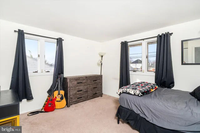 a bedroom with a bed and dresser with mirror
