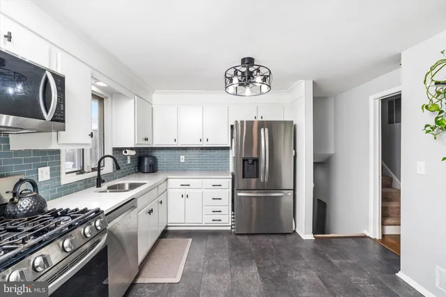 a kitchen with a refrigerator and a stove top oven
