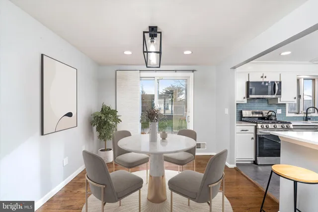 a dining room with furniture a chandelier and wooden floor