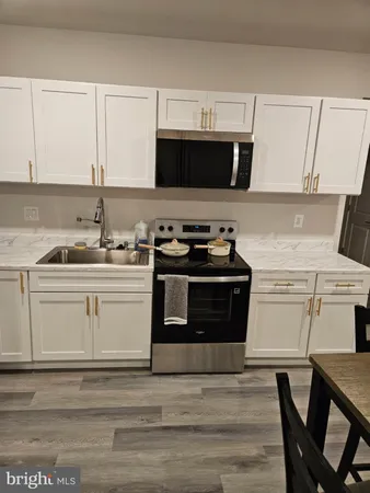 a kitchen with stainless steel appliances a stove a microwave a sink and cabinets