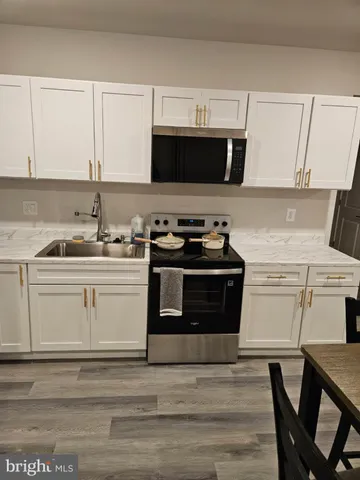 a kitchen with stainless steel appliances a stove a microwave a sink and cabinets