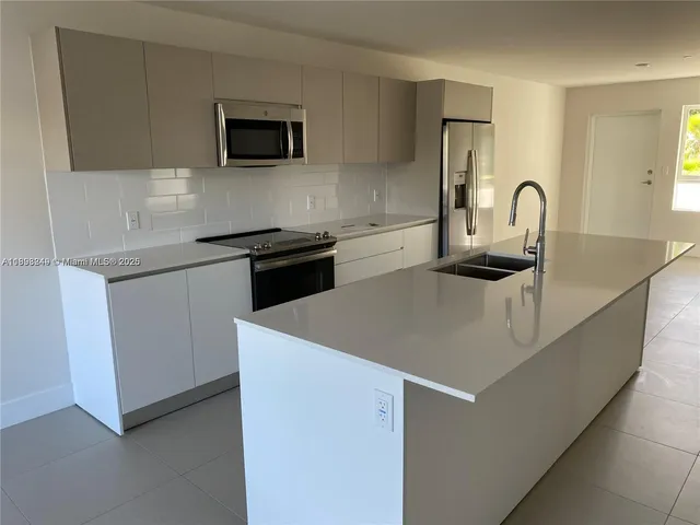 a kitchen with granite countertop white cabinets and stainless steel appliances