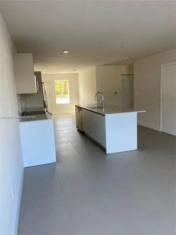 a living room with furniture and a kitchen