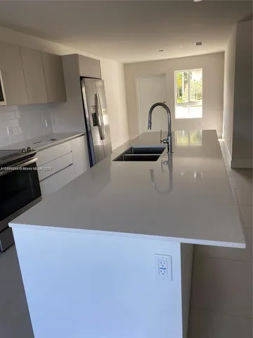 a close view of a sink a counter space and a stove in a kitchen