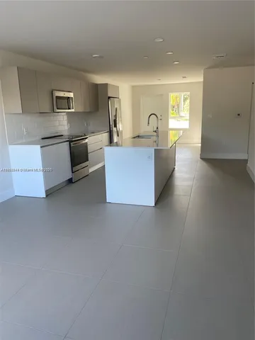 a kitchen with stainless steel appliances granite countertop a refrigerator a sink dishwasher and a stove