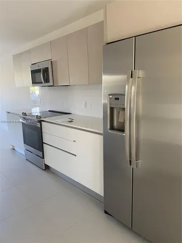 a kitchen with stainless steel appliances a refrigerator sink and stove