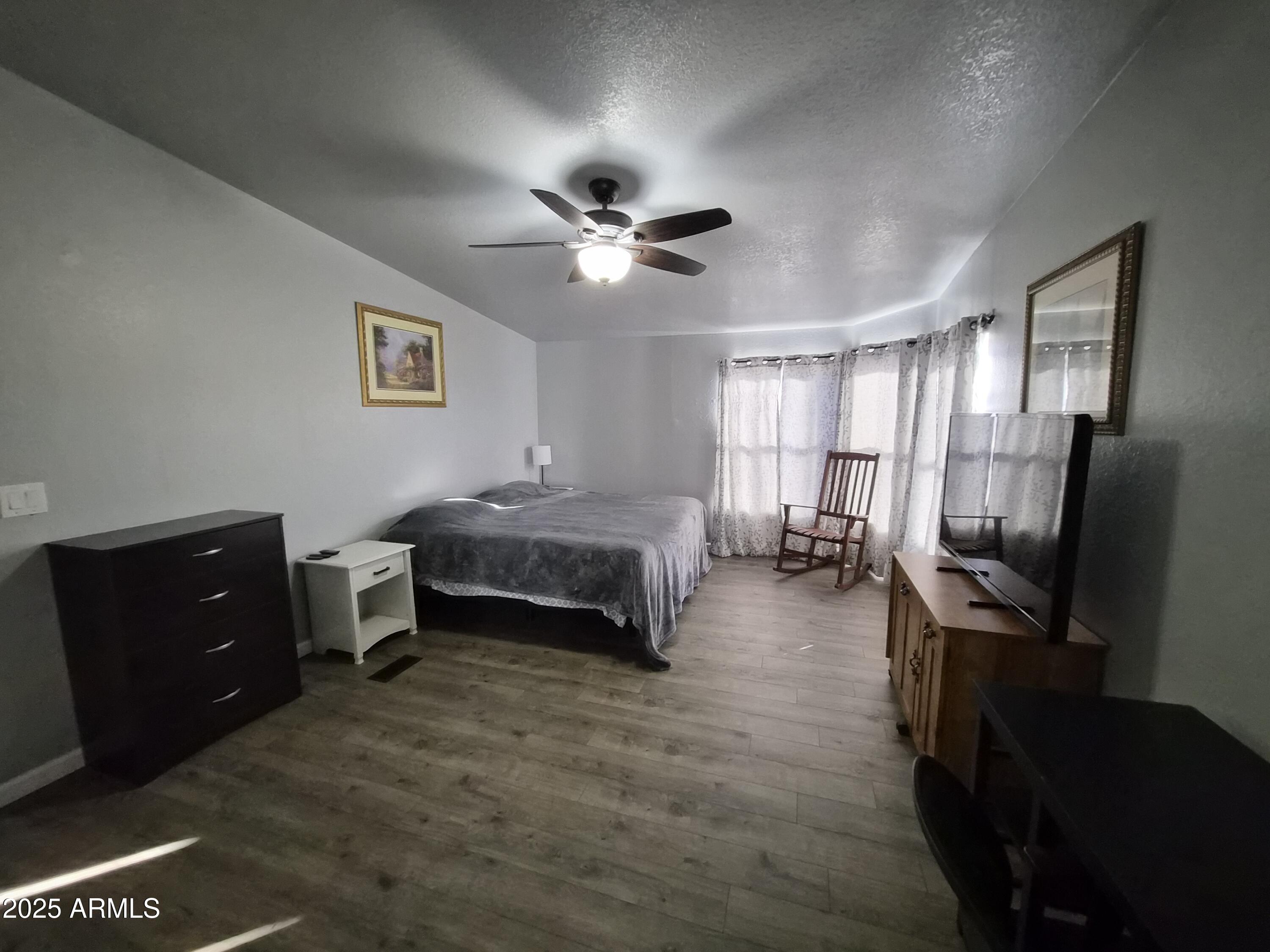 51033 North Mockingbird Road Wickenburg, AZ 85390 - Photo 24 of 51 a bedroom with furniture and a flat screen tv