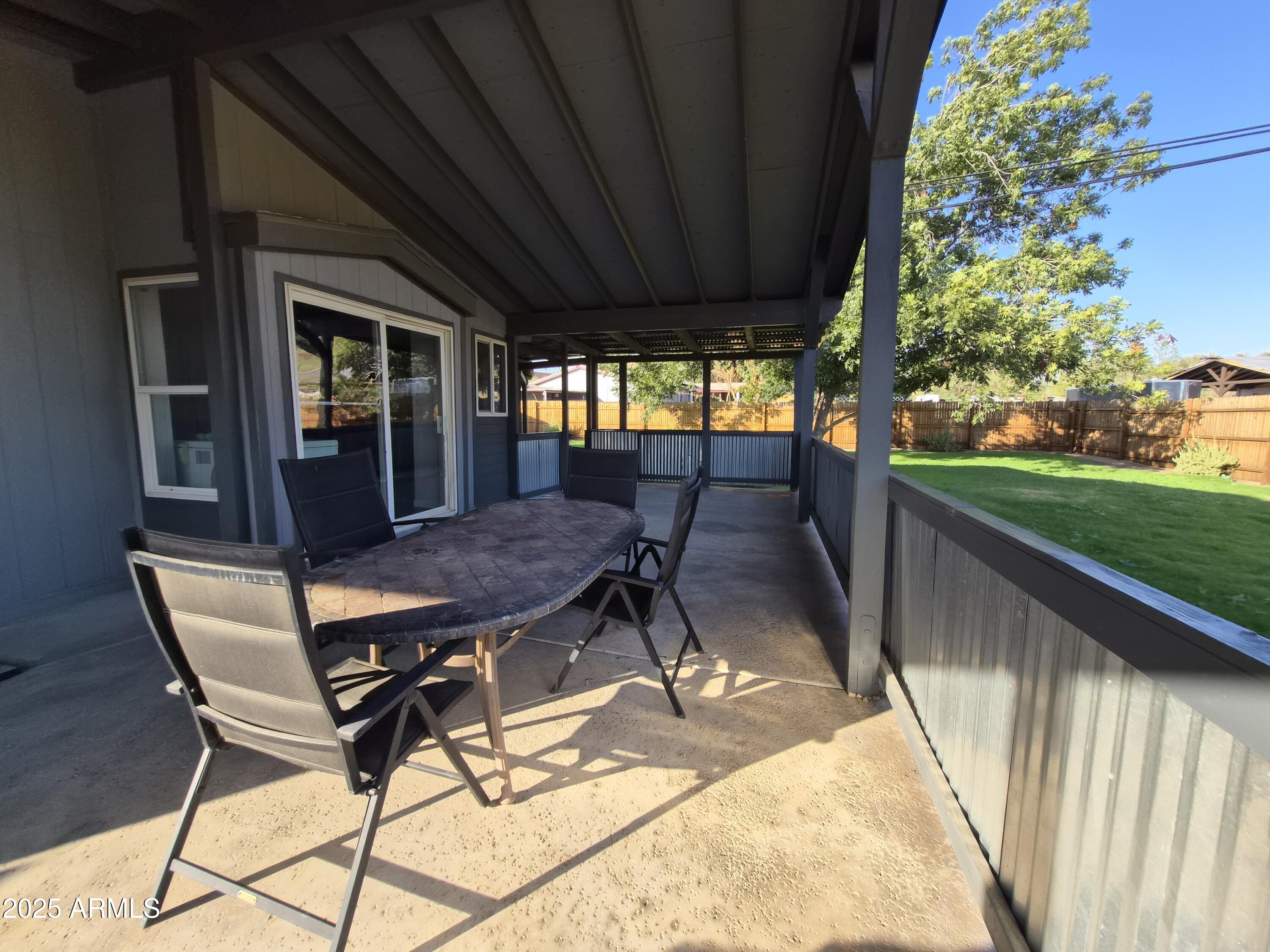 51033 North Mockingbird Road Wickenburg, AZ 85390 - Photo 42 of 51 a view of a patio with table and chairs with wooden floor and fence