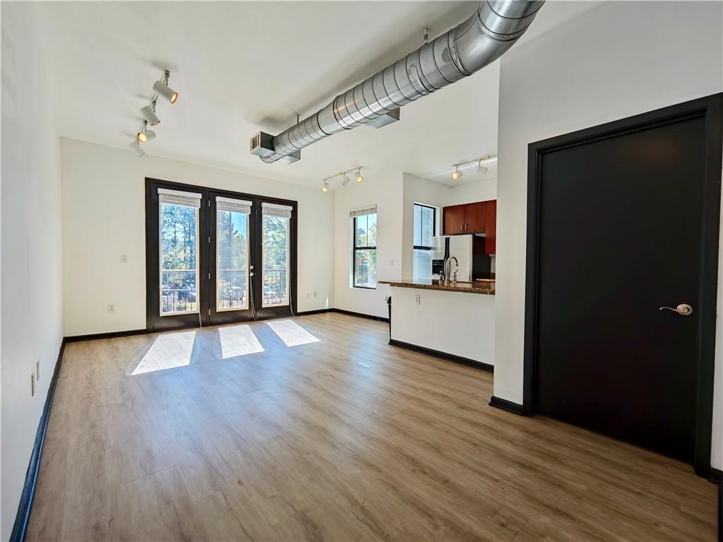 5300 Peachtree Road, Unit 2401 Chamblee, GA 30341 - Photo 3 of 24 a view of an empty room with wooden floor and a kitchen