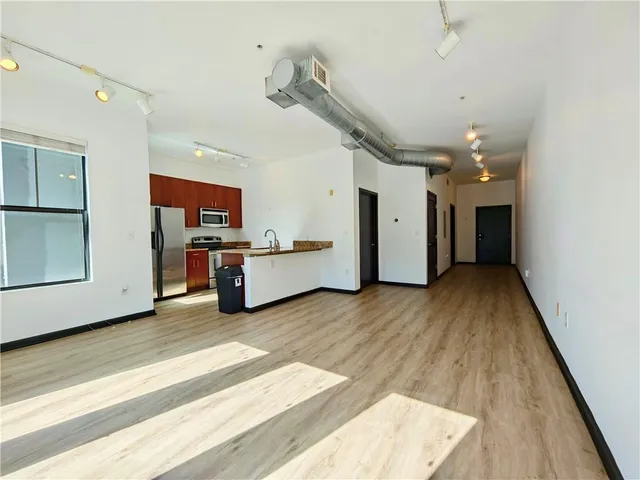 a view of a kitchen with furniture and wooden floor