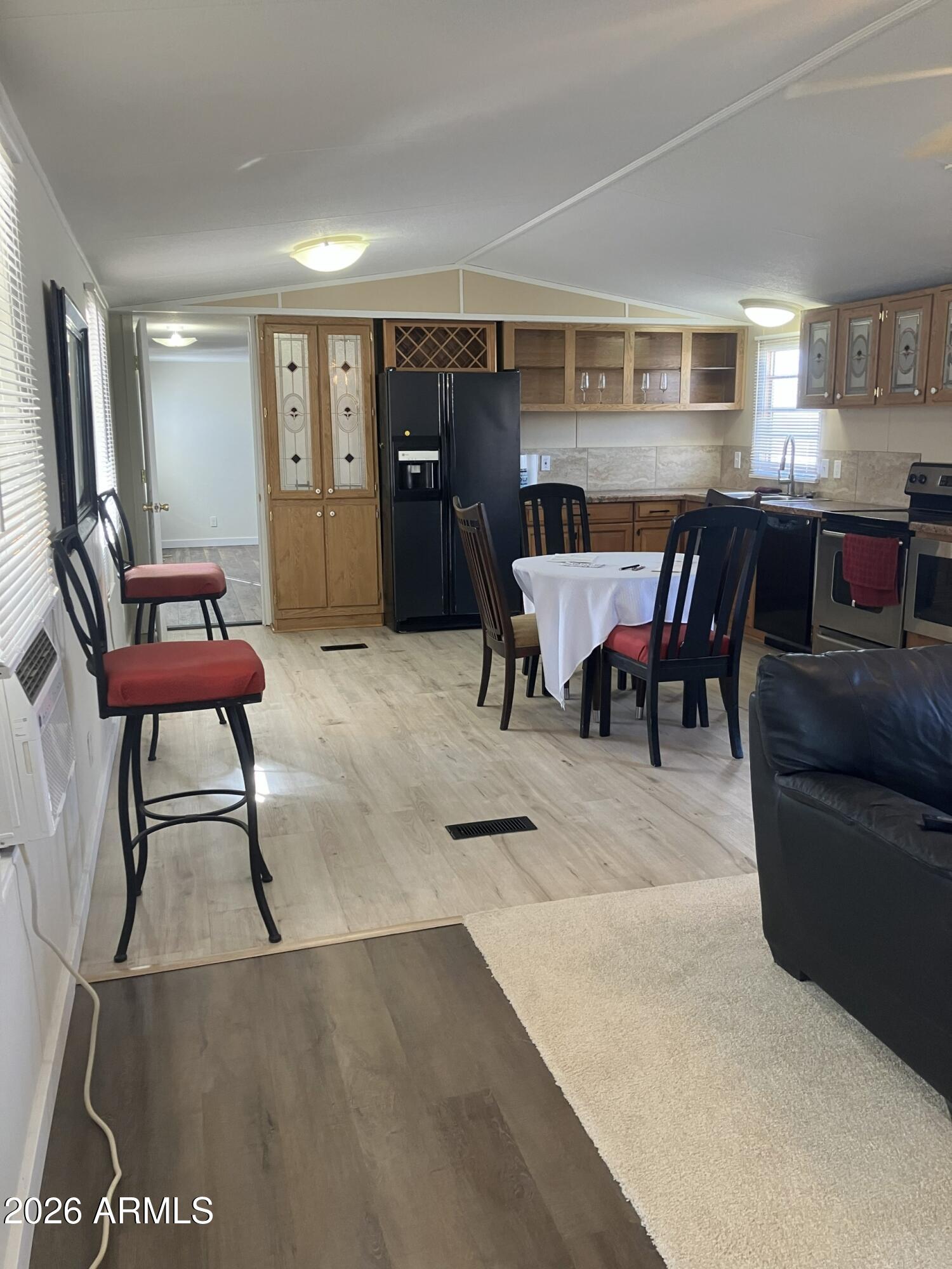 2523 East Contention Mine Road, Unit 41 Phoenix, AZ 85032 - Photo 7 of 19 a open kitchen with stainless steel appliances kitchen island granite countertop a dining table chairs and a refrigerator
