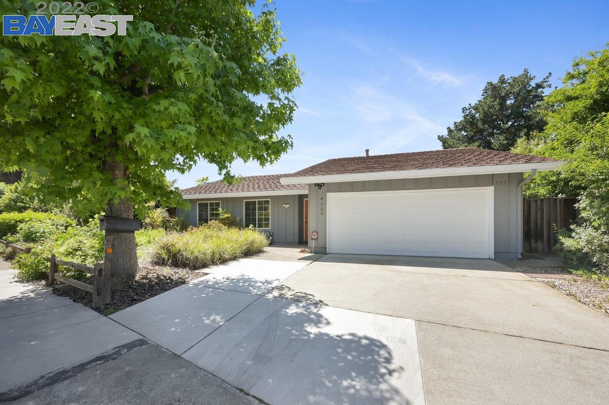 a front view of a house with a garden and yard