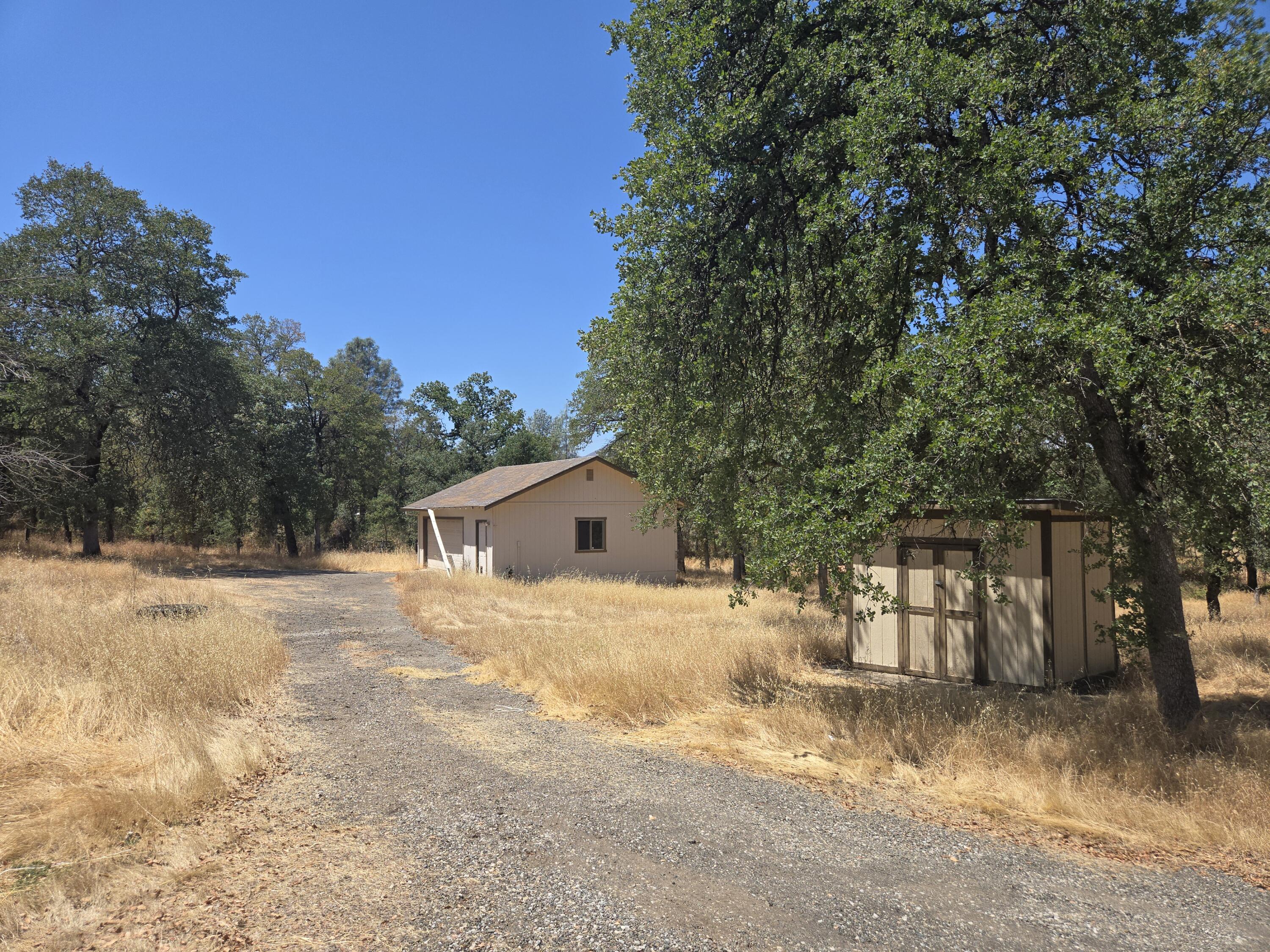 18353 Old Oasis Road Redding, CA 96003 - Photo 5 of 22 a yellow house with trees in front of it