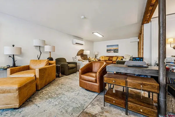 a living room with furniture a large window and dresser