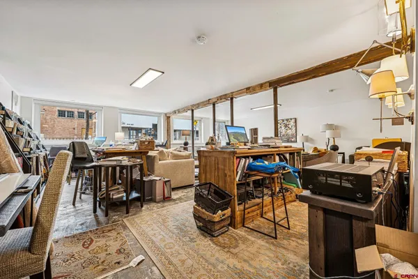 a view of a workspace with furniture and rug