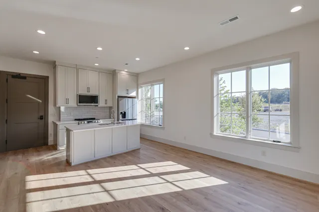 a large kitchen with stainless steel appliances granite countertop a stove a sink and a refrigerator