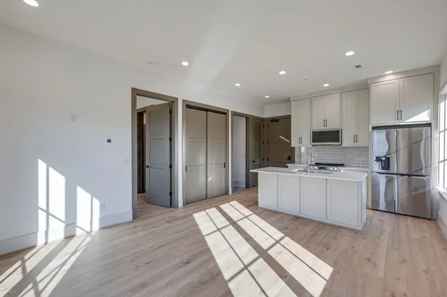 a kitchen with a refrigerator and a stove top oven