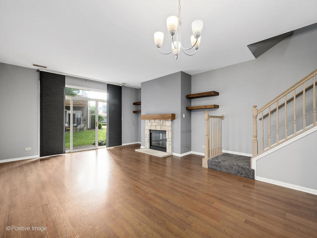 835 Genesee Drive Naperville, IL 60563 - Photo 3 of 18 a view of an empty room with wooden floor fireplace and a window