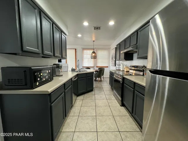a kitchen with sink a faucet and chairs