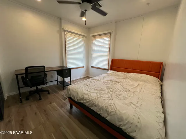 a view of a workspace with wooden floor and a window