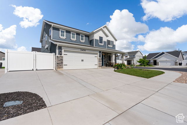 3456 South Linden Way Syracuse, UT 84075 - Photo 48 of 50 View of front of house featuring an attached garage, stone siding, a gate, driveway, and a porch