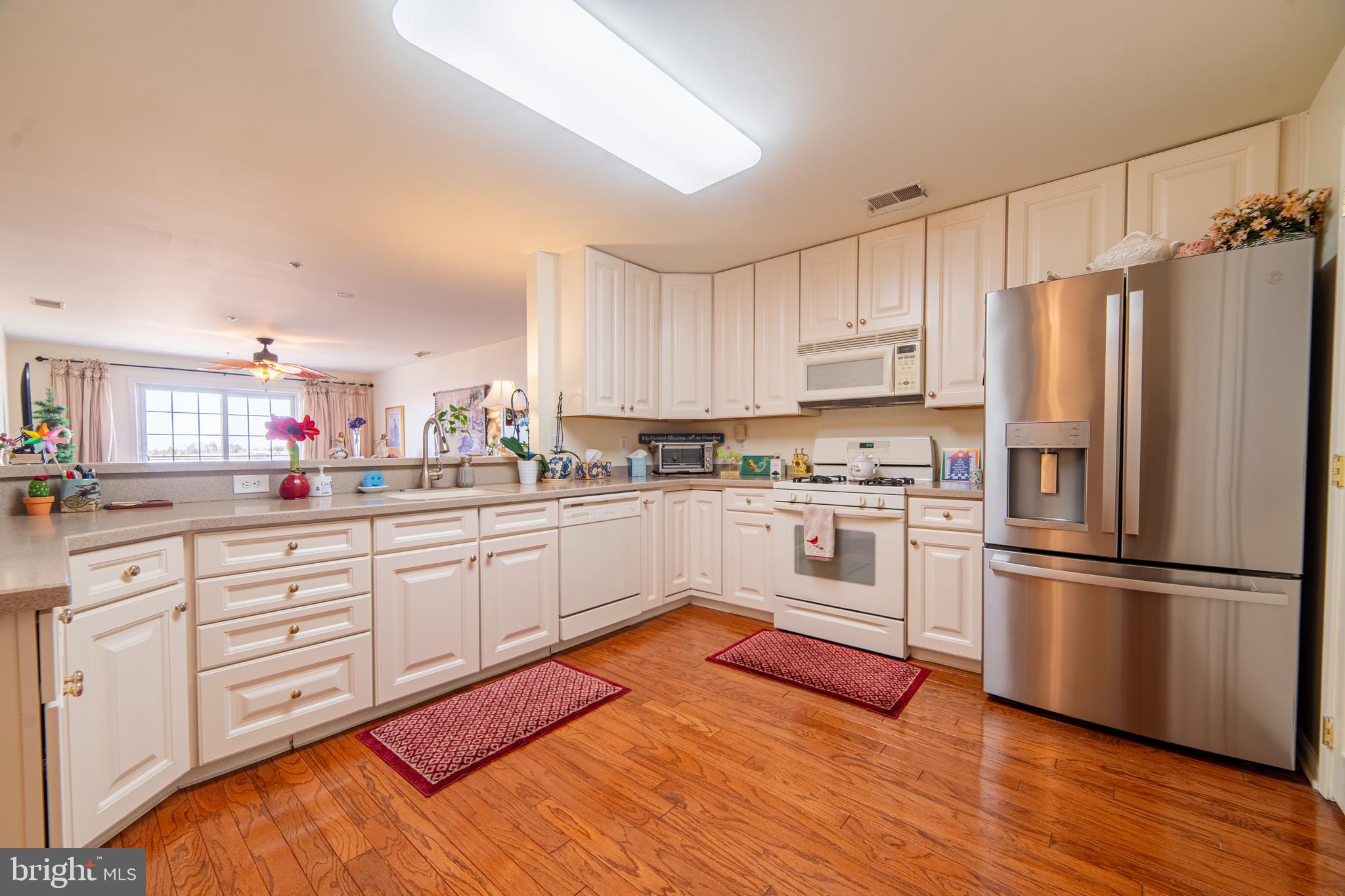 61 Dockside Drive Somers Point, NJ 08244 - Photo 9 of 23 a kitchen with stainless steel appliances white cabinets and wooden floors