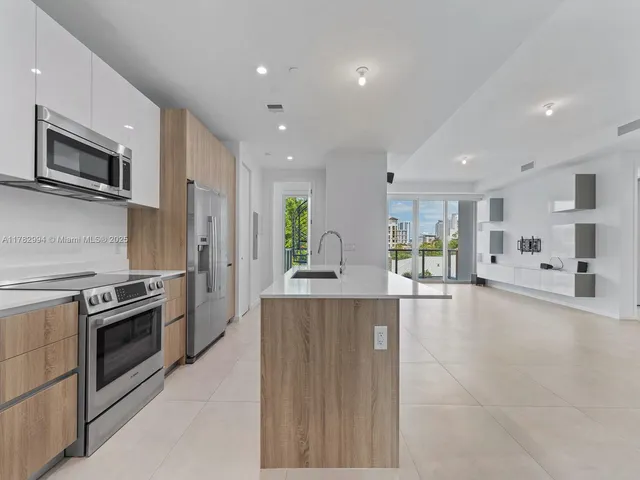 a large kitchen with a sink and refrigerator
