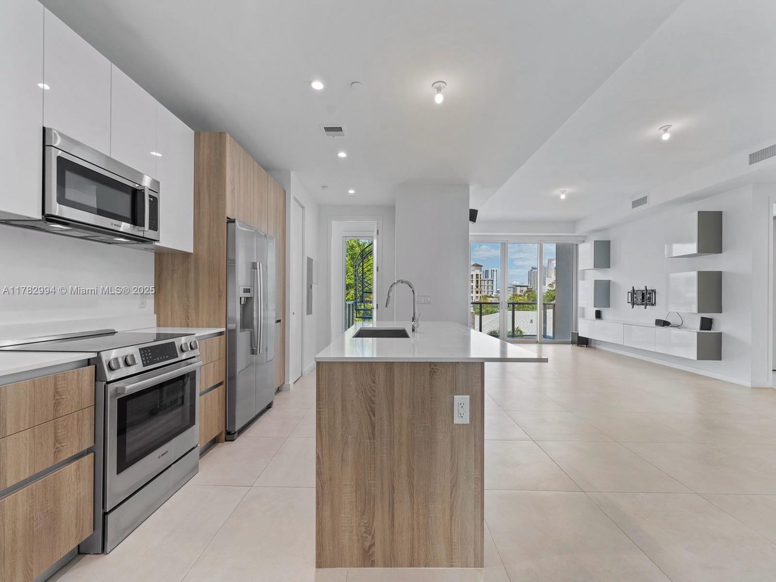 529 Southwest 11th Street, Unit 303 Miami, FL 33129 - Photo 12 of 64 a large kitchen with stainless steel appliances kitchen island granite countertop a large counter top stainless steel appliances and cabinets