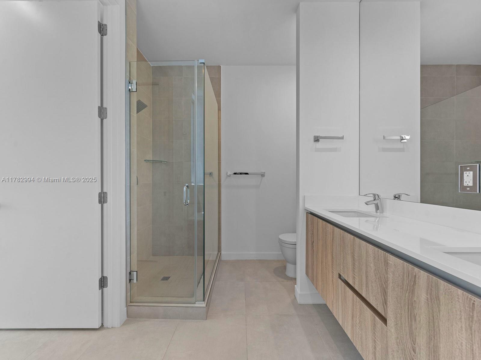 529 Southwest 11th Street, Unit 303 Miami, FL 33129 - Photo 31 of 64 a bathroom with a double vanity sink and mirror