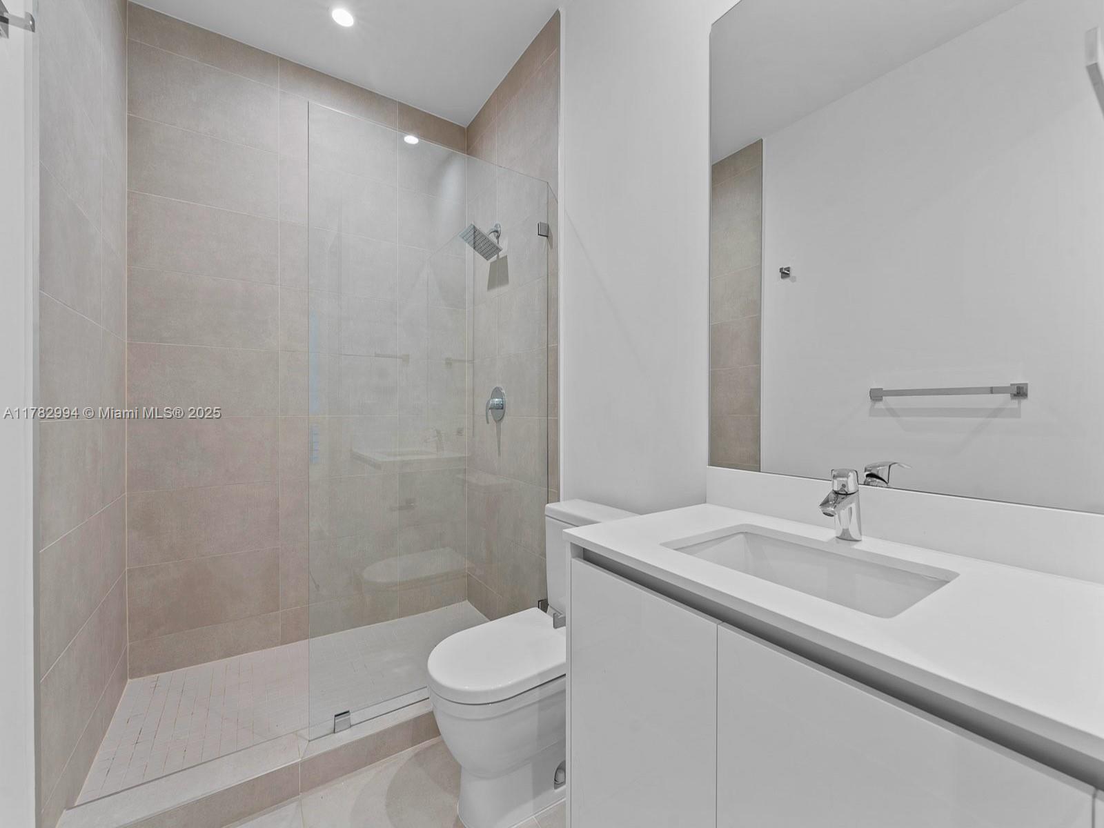 529 Southwest 11th Street, Unit 303 Miami, FL 33129 - Photo 36 of 64 a bathroom with a sink a toilet and shower