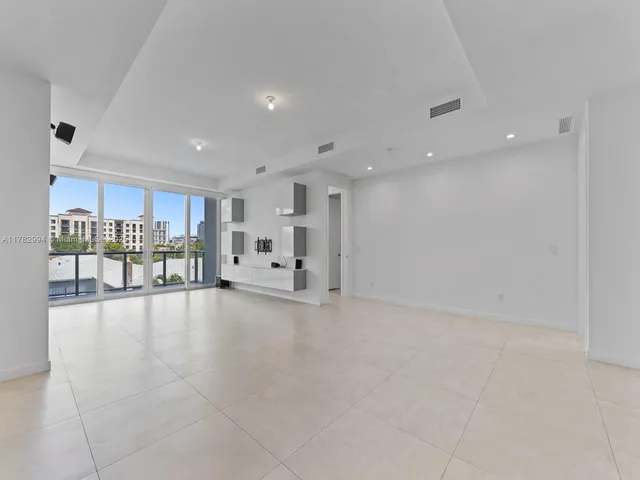 a view of an empty room with a kitchen