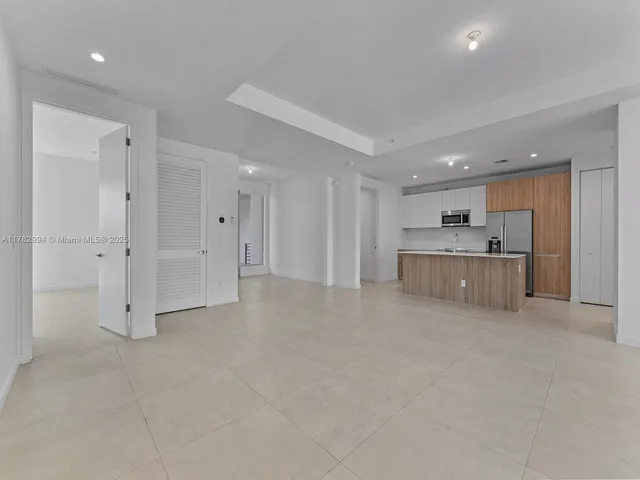 a kitchen with kitchen island a sink stainless steel appliances and white cabinets