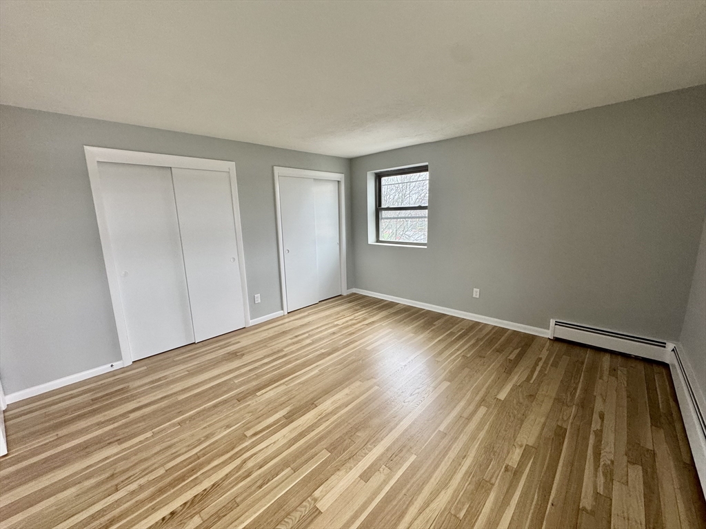 97 Spring Street, Unit C2 Boston, MA 02132 - Photo 6 of 11 a view of empty room with wooden floor