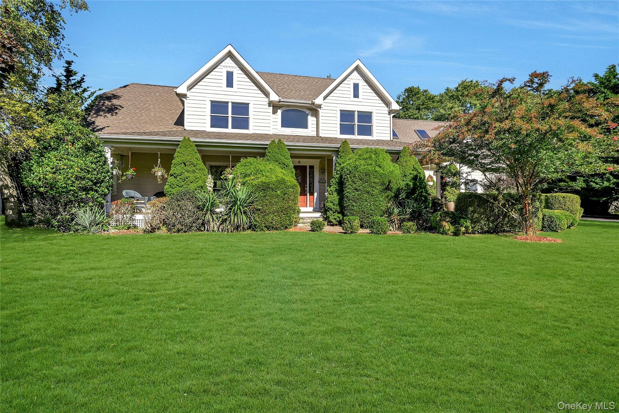 a front view of a house with a yard and trees