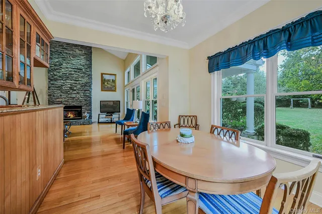 a dining room with furniture a large window and wooden floor