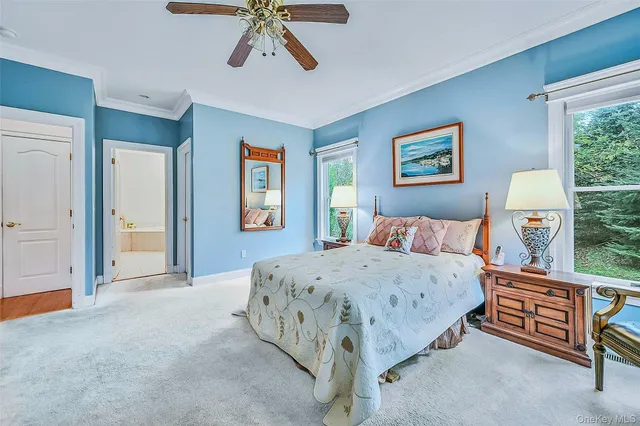 a bedroom with a bed a dresser and painting