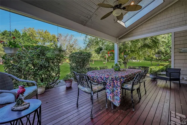 a view of a patio with table and chairs potted plants with wooden floor and fence