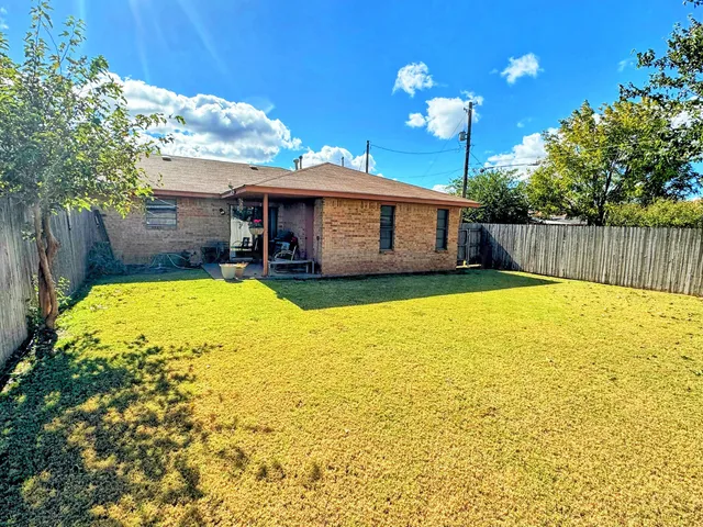 a view of a patio with table and chairs potted plants with wooden floor and fence