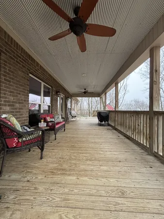 a living room with couches and kitchen view with wooden floor