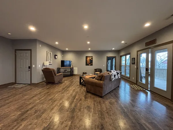 a kitchen with stainless steel appliances granite countertop a stove top oven a sink a dining table and chairs