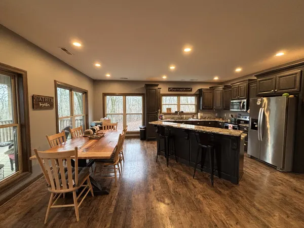 a large kitchen with stainless steel appliances granite countertop a sink stove and refrigerator