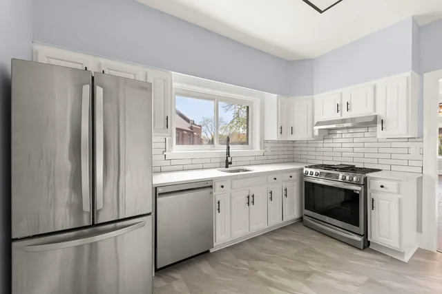 a kitchen with stainless steel appliances granite countertop a refrigerator sink and stove