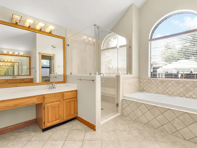 a spacious bathroom with a double vanity sink a mirror and a bathtub