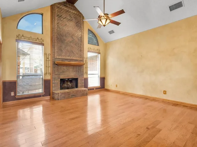 a view of a livingroom with wooden floor and a ceiling fan