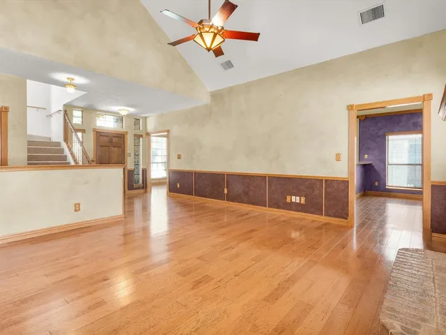 a view of empty room with wooden floor and fireplace