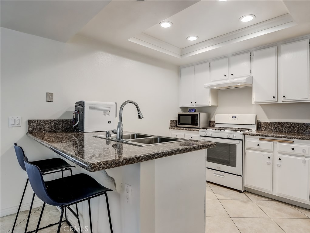 98 Greenfield, Unit 95 Irvine, CA 92614 - Photo 12 of 48 a kitchen with stainless steel appliances granite countertop a sink and cabinets
