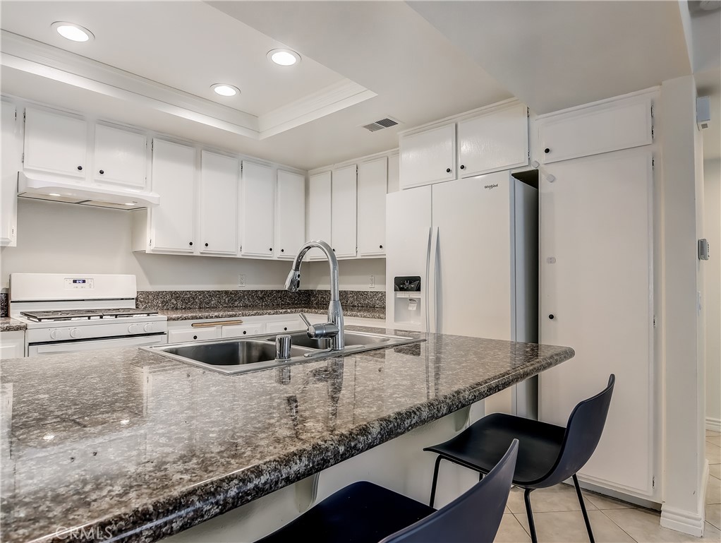 98 Greenfield, Unit 95 Irvine, CA 92614 - Photo 13 of 48 a kitchen with kitchen island a counter top space a sink stainless steel appliances and cabinets