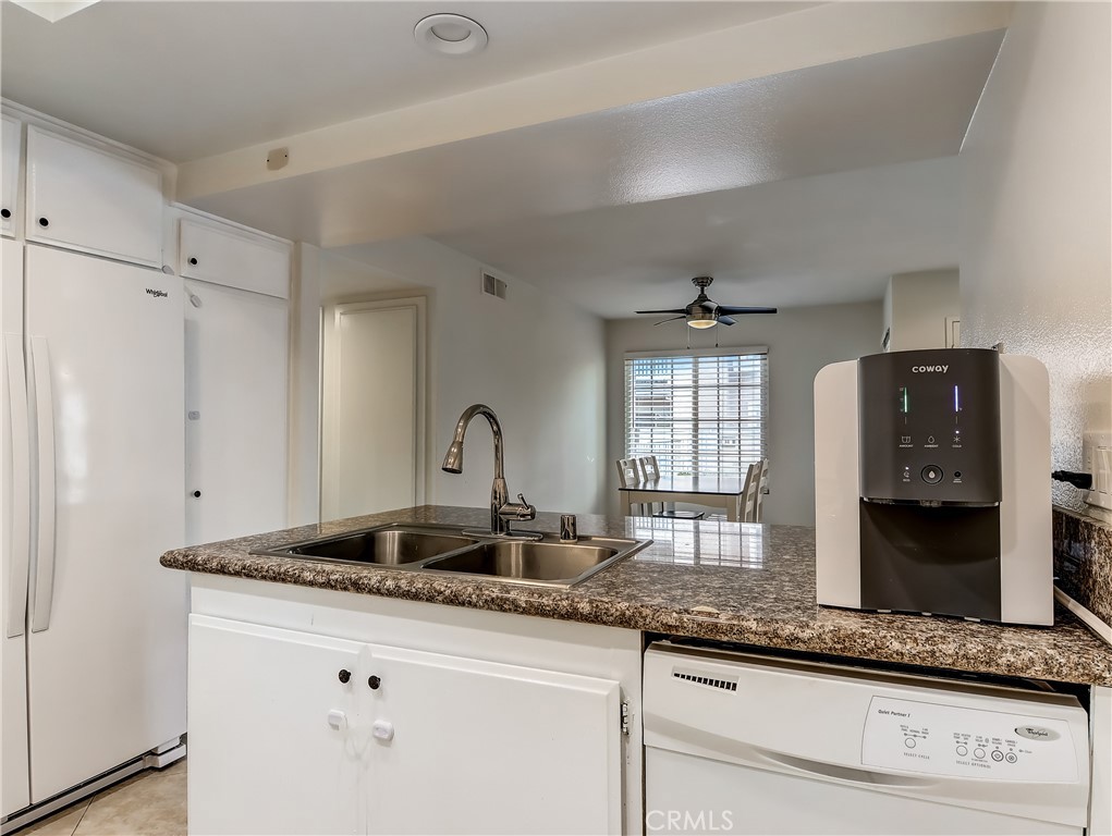 98 Greenfield, Unit 95 Irvine, CA 92614 - Photo 17 of 48 a kitchen with granite countertop a sink and white cabinets