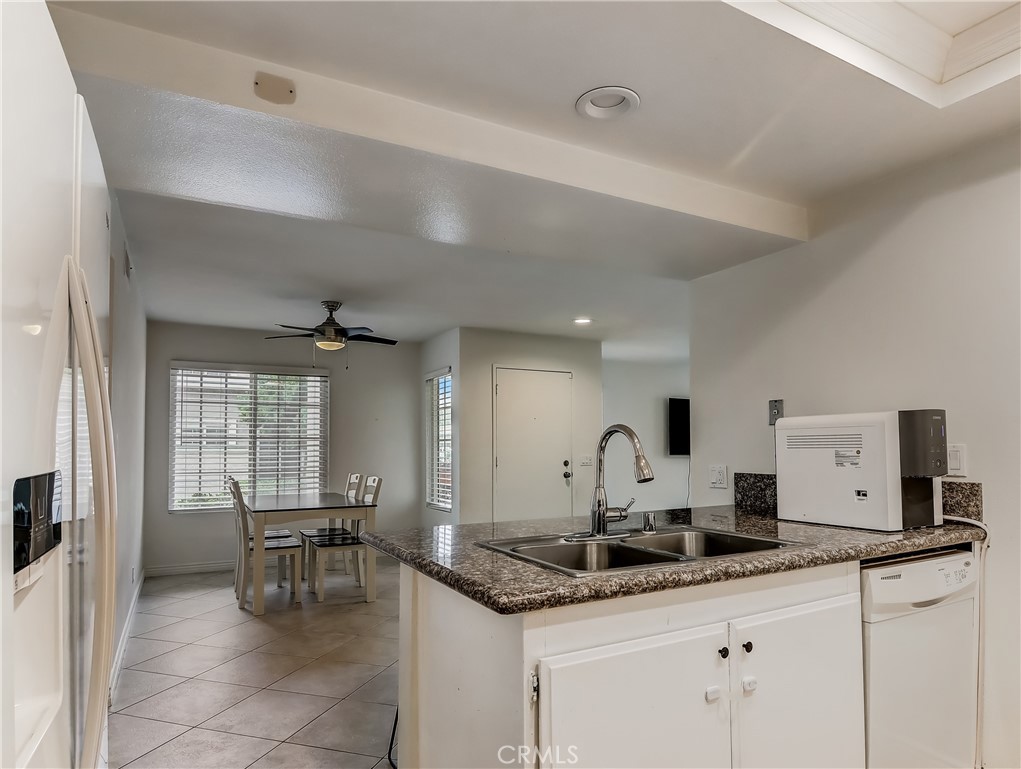 98 Greenfield, Unit 95 Irvine, CA 92614 - Photo 18 of 48 a kitchen with granite countertop a sink and chairs